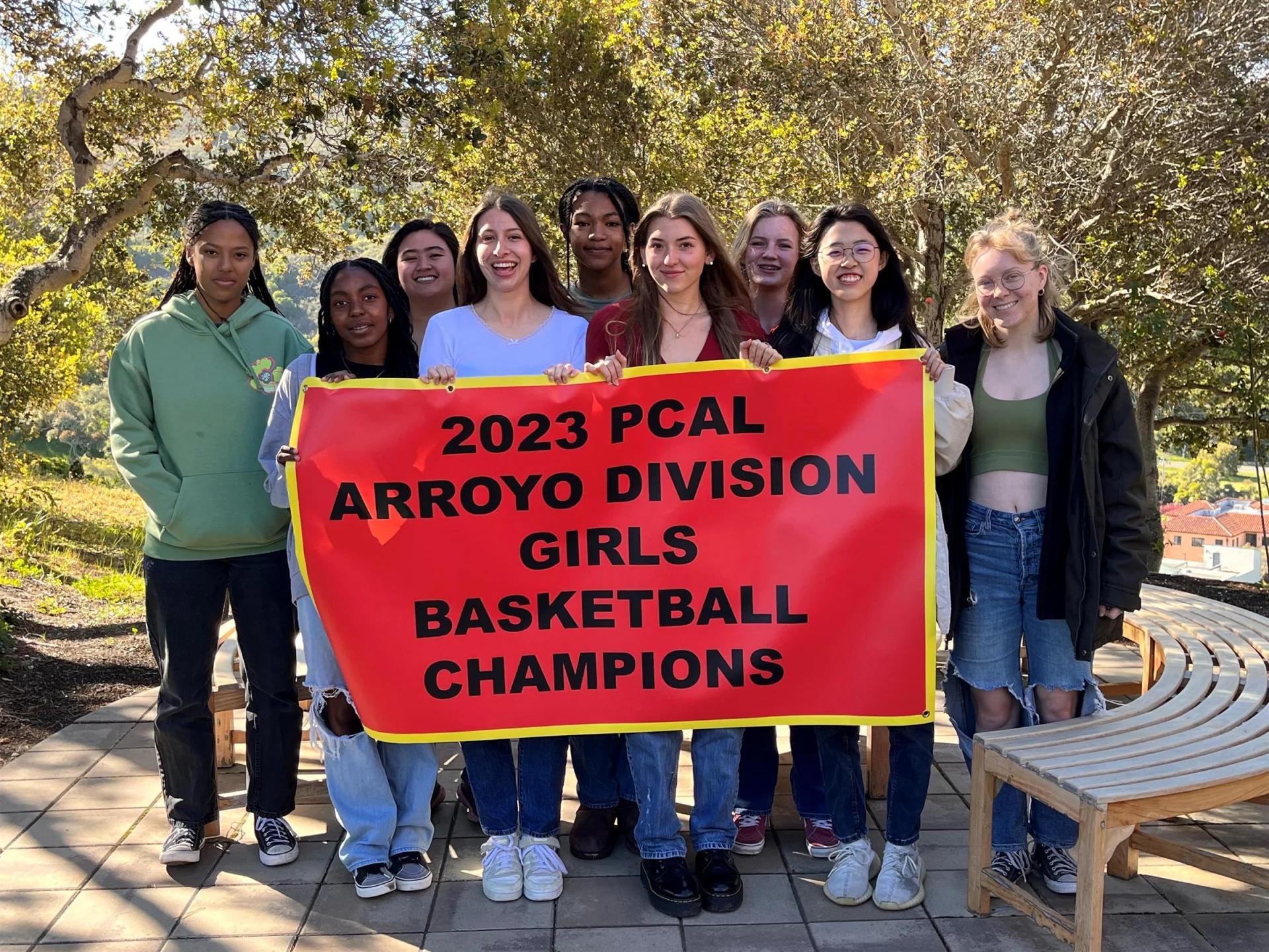 York girls basketball team with ARROYO championship banner