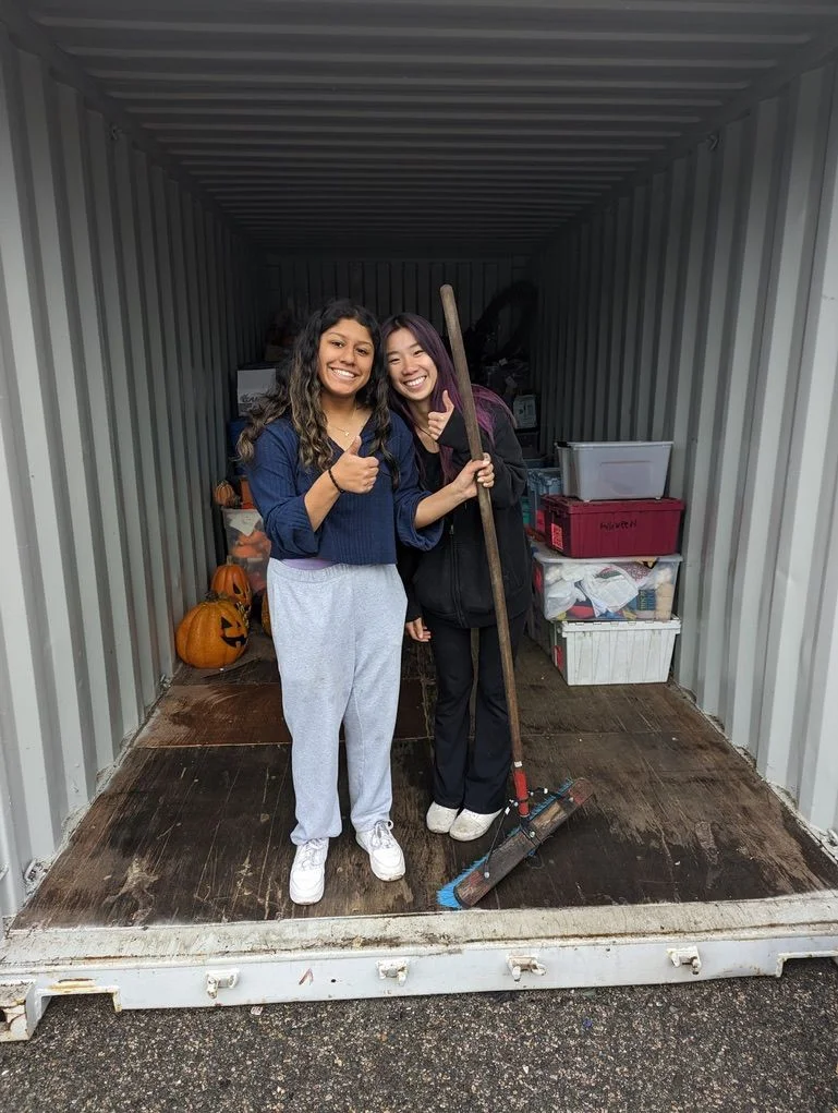 two students sweeping out a tractor trailer